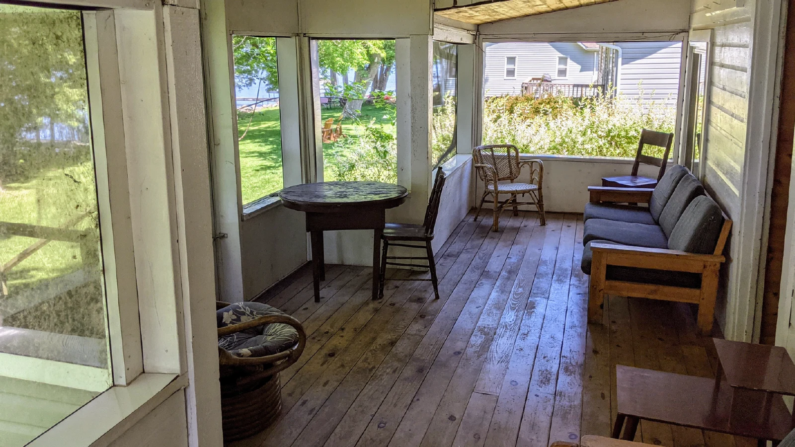 Pigeon Lake Resort Cottage three porch with table, chairs, and outdoor view.